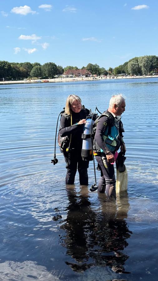 Zwei Taucher stehen im flachen Wasser