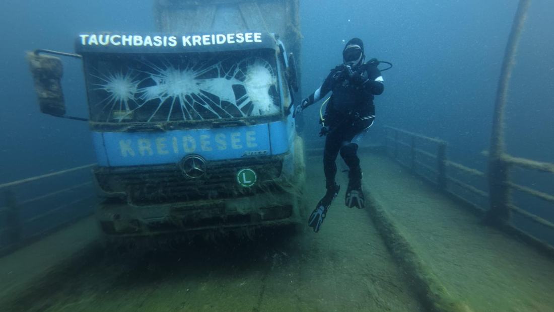 Taucher neben dem versunkenen Lkw der Tauchbasis Kreidesee