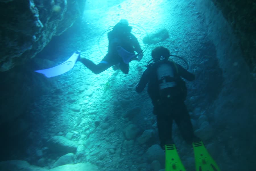 Taucher in einer Höhle im Gegenlicht